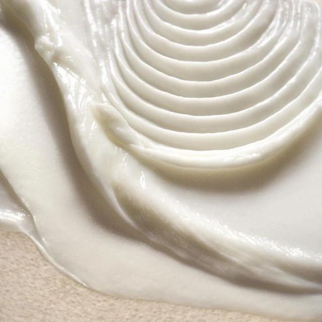 Close-up of a thick, white cream or lotion with textured ridges and smooth application, ideal for beauty or skincare product presentation.