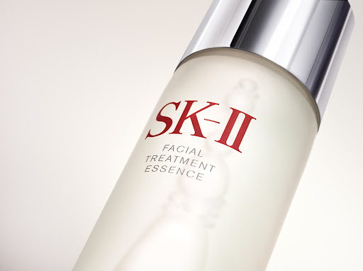 Close-up of an SK-II Facial Treatment Essence bottle against a bright background, showcasing skincare product details and branding.