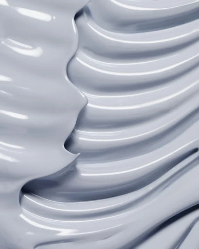 Abstract close-up of a thick grey cream with shiny texture, showing a wavy pattern and smooth surface, perfect for beauty product.