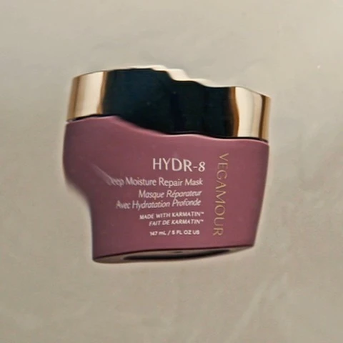 Vegamour HYDR-8 Deep Moisture Repair Mask jar. Gold lid with a deep mauve jar. Text on jar includes the brand name.  