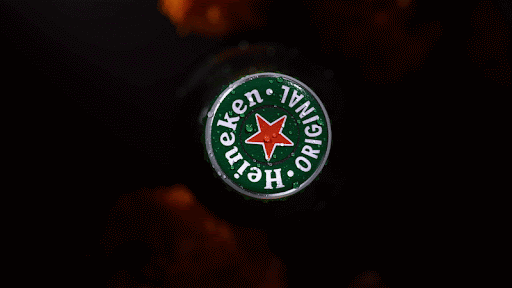 Close-up of a Heineken beer bottle cap with its green and red logo against a dark, blurred background.