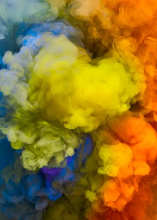 An abstract image showcasing swirling clouds of blue, yellow, and orange smoke blending together, creating a vibrant and dynamic visual effect.