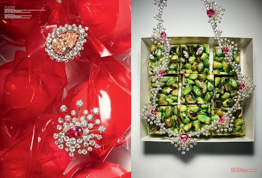 High-fashion shot showcasing diamond jewelry adorned with gemstones, set against red balloons and green pistachio candy in a square box.
