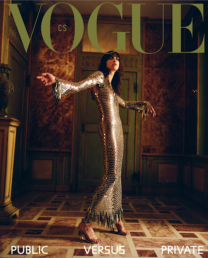Vogue cover featuring a woman in a silver dress with fringe, standing in an ornate room with a patterned floor and walls, with magazine text.