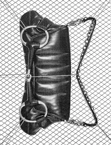 Elevated shot of a black faux-leather handbag with silver chain handle, resting on a diamond-patterned wire mesh.