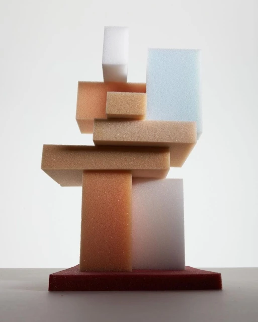 Abstract arrangement of geometric foam blocks in pastel tones against a white background, minimalist and modern aesthetic.