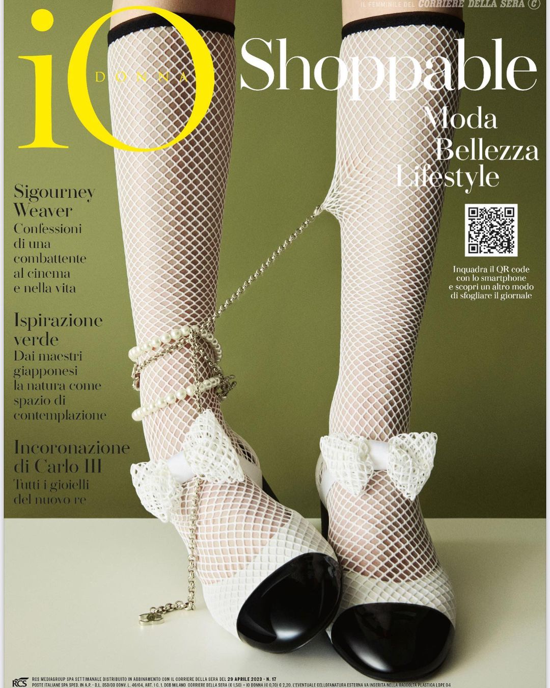 Fashion magazine cover featuring legs in fishnet stockings, pearl accessories, and white bow heels against an olive green backdrop.