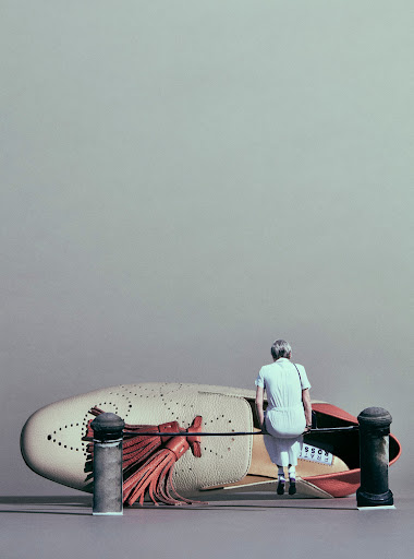 Miniature woman in jumpsuit sitting on a metal pipe near a giant loafer shoe, with two black posts on a light gray background.