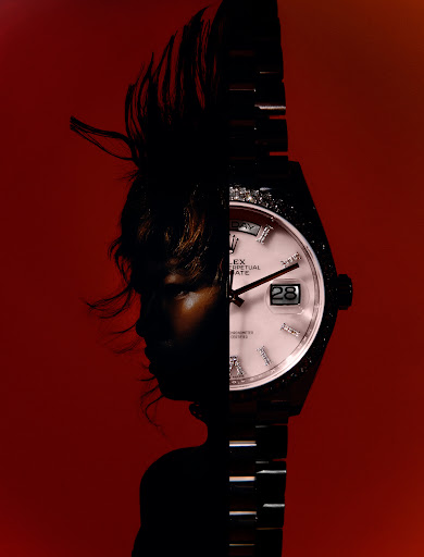 Dramatic composite of a wristwatch and a silhouetted person against a red backdrop, blending horology with abstract portraiture.