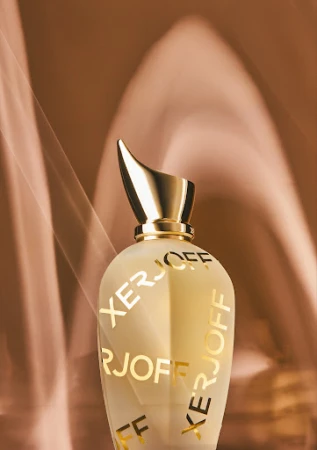 Elegant perfume bottle with a gold cap against a soft brown background, branded with XERJOFF lettering, product photography.