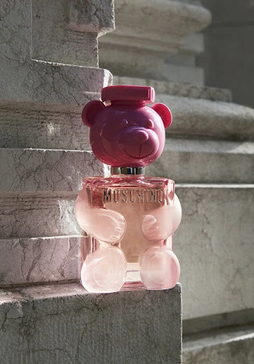 Moschino Toy 2 Bubble Gum Eau de Toilette perfume bottle in the shape of a pink teddy bear against a marble background.