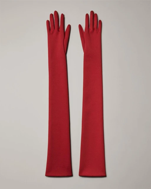 Pair of long red opera gloves on a neutral background. Fashionable and elegant evening gloves.