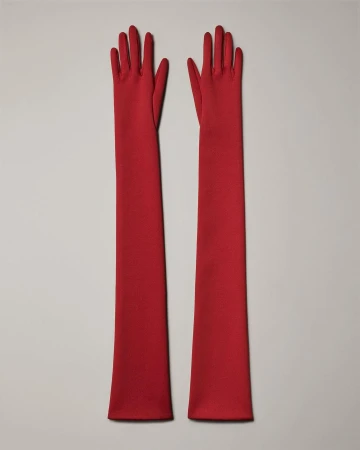 Pair of long red opera gloves on a neutral background. Fashionable and elegant evening gloves.