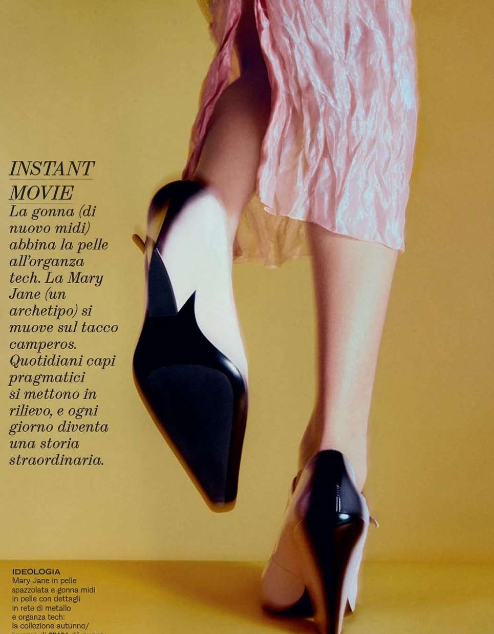 Fashion editorial shot showcases black-and-white high heels on a model wearing a light pink midi dress against a yellow backdrop.