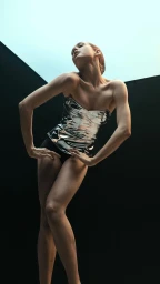 Woman in a metallic silver corset posing dramatically against a dark studio background by photographer Marcus Eriksson