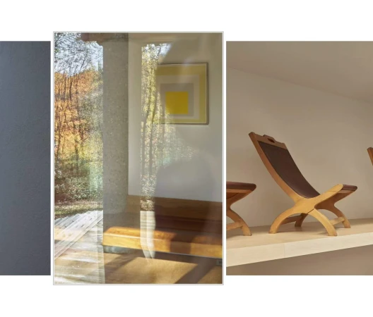 Interior scene with mid-century modern wood chairs and side table arranged on a platform against white walls, filtered light, and autumn colors.