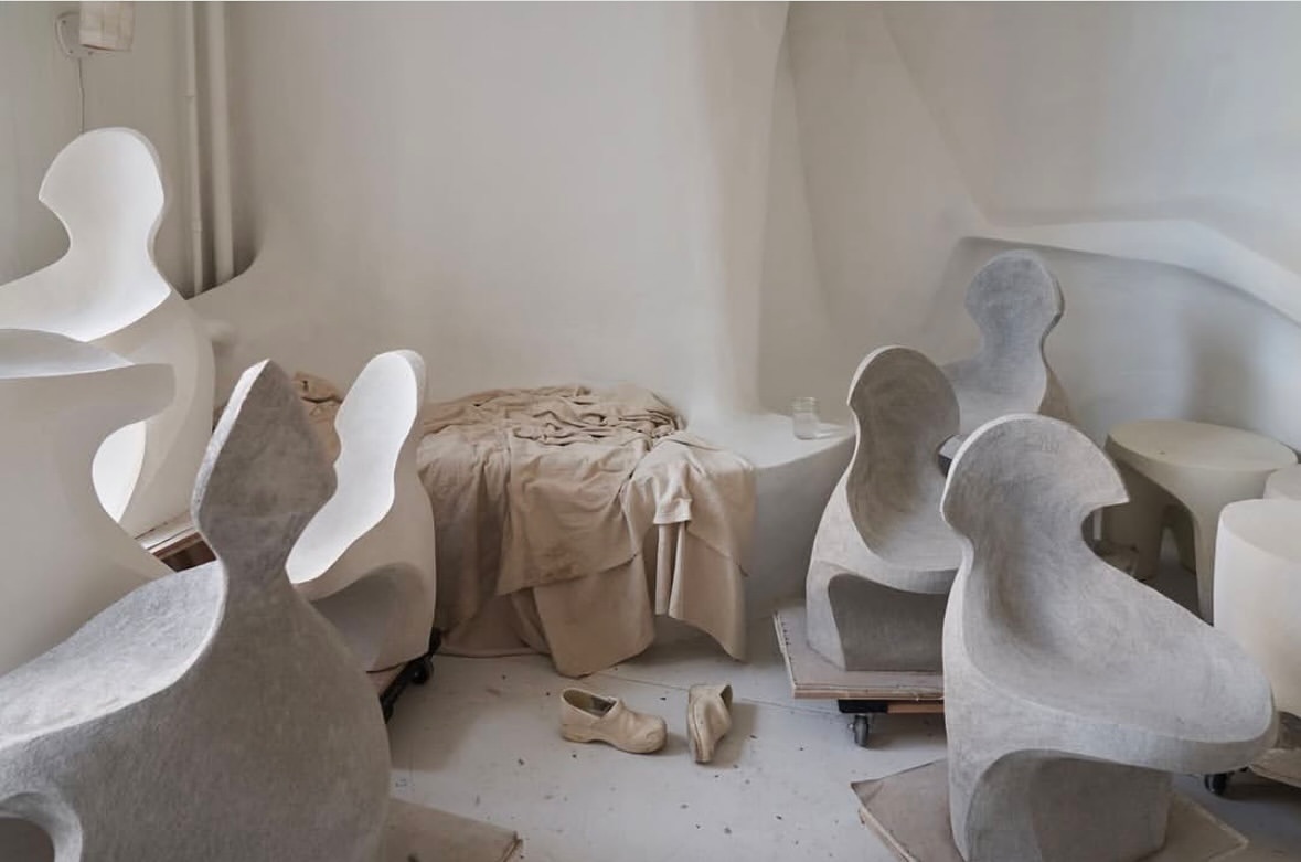 Sculptural chairs in a bright studio-like space, showing modern furniture design with soft, diffused lighting and minimalist aesthetics.