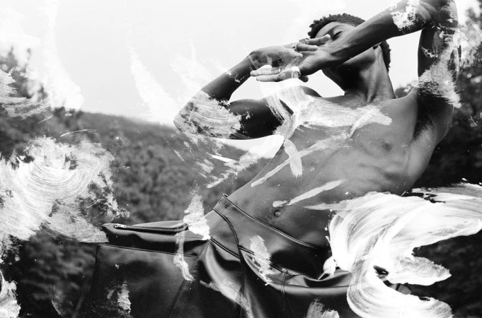 Black-and-white portrait of a shirtless man posing with painted brushstroke overlays directed by Matt Jones