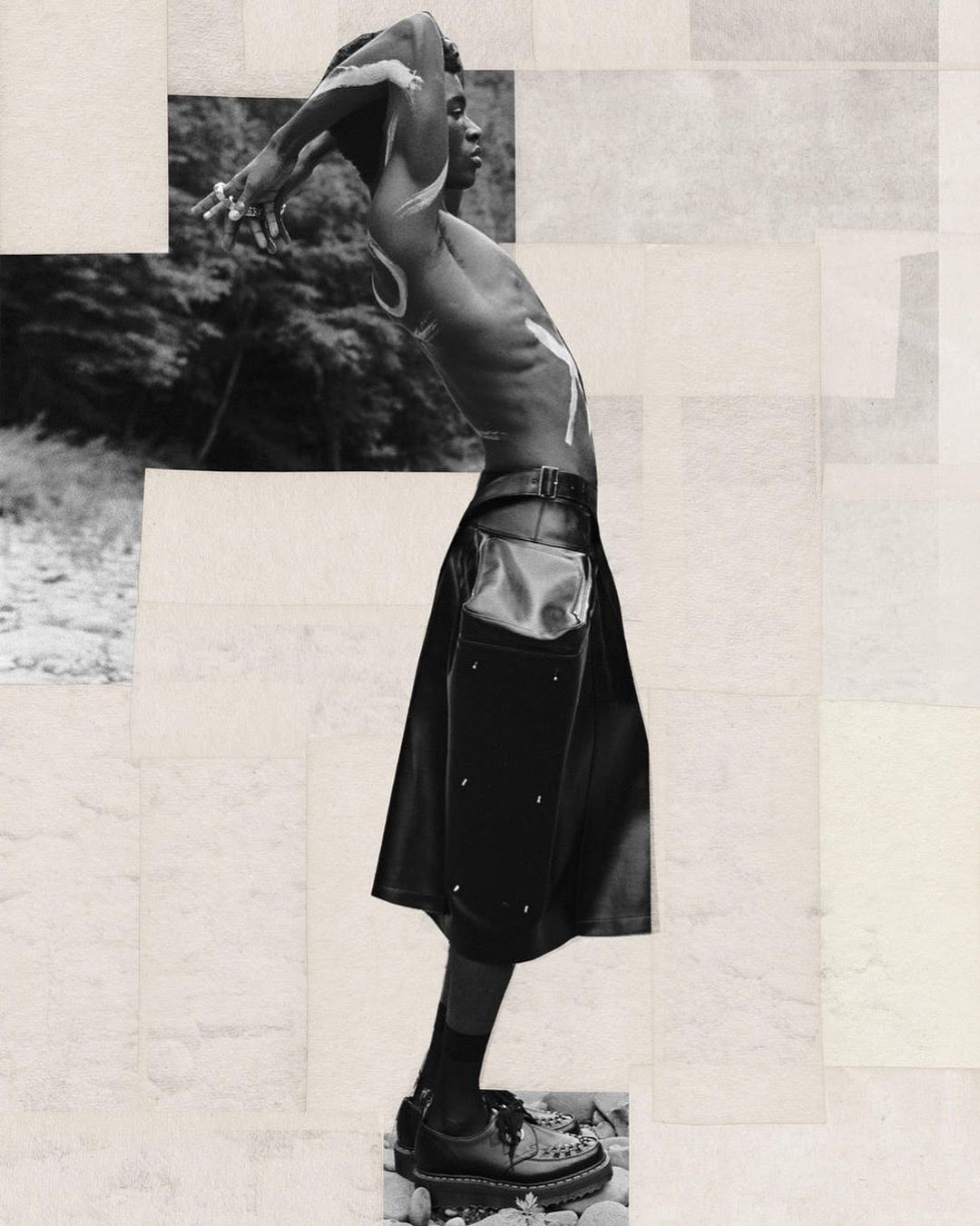 Monochrome portrait of a shirtless Black male model in a kilt, with white body paint, posing outdoors near foliage against a geometric collage background.
