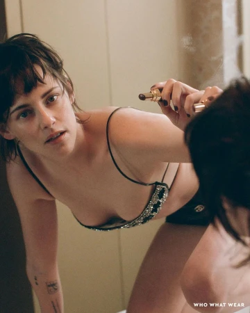 Close-up portrait of actress Kristen Stewart leaning toward a mirror holding a lipstick by director Matt Jones
