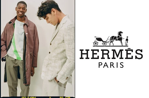 Two adult men in stylish jackets and pants pose indoors; an Hermès logo with horse and carriage is displayed alongside them.