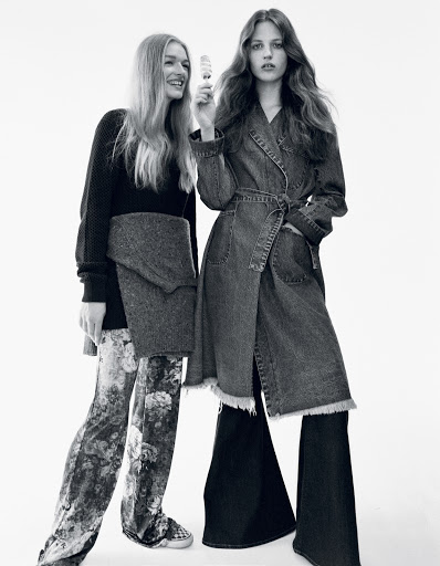 Two women in a monochrome fashion shot. One woman holds a skincare product. Denim and floral patterns are prominent against a white background.