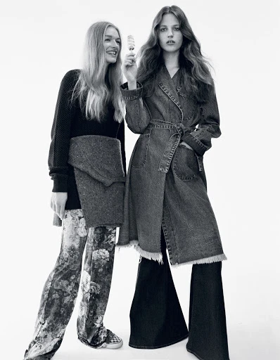 Two women in a monochrome fashion shot. One woman holds a skincare product. Denim and floral patterns are prominent against a white background.