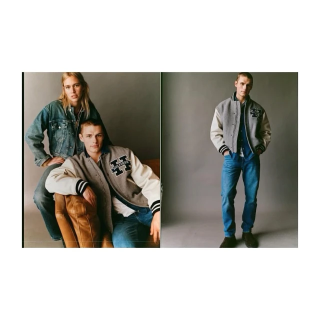 Two young adults in studio setting, wearing varsity jackets and jeans, seated and standing against a gray backdrop. Fashion photography.