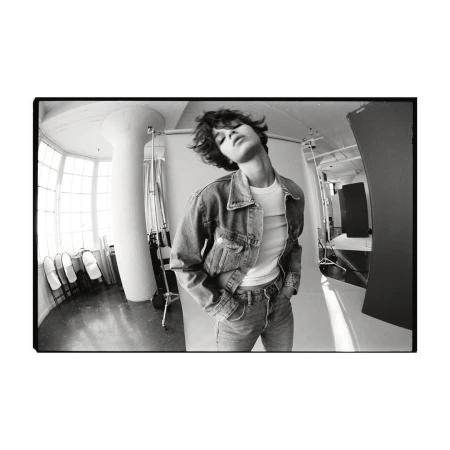 Model with dark short hair wearing a denim jacket and jeans in a photo studio by photographer Matteo Montanari.