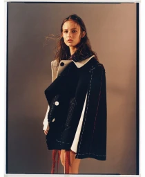 Young female model wearing a black coat with white topstitching photographed by Matteo Montanari