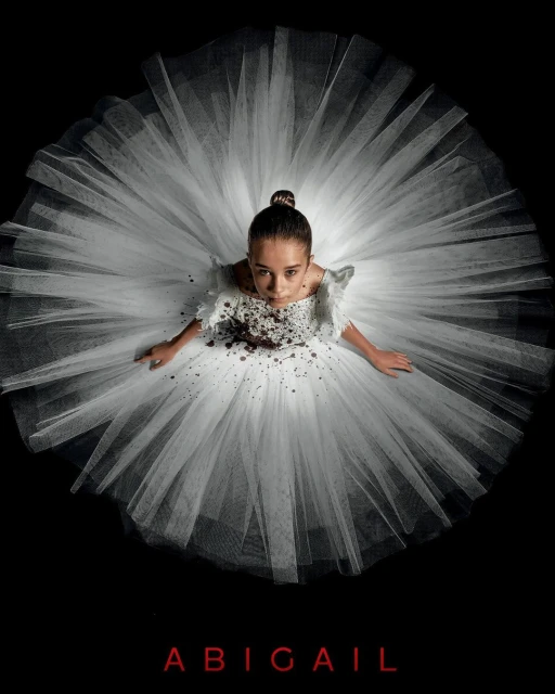 Eye-level shot of a young girl in a white tutu with brown accents against a black backdrop, looking up at the camera with a serious expression.