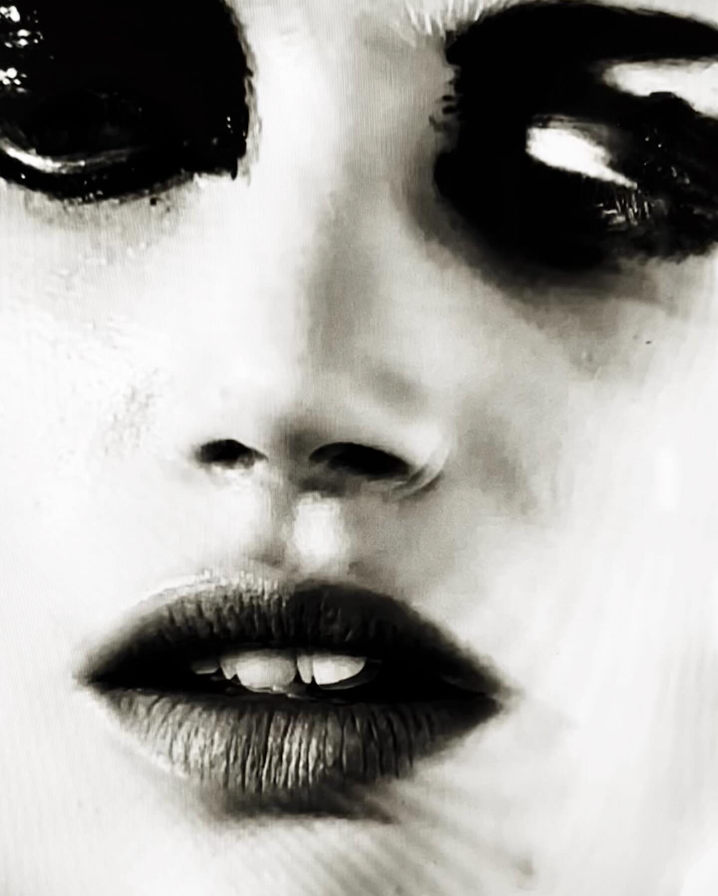 Close-up artistic portrait of an adult female with striking black eye makeup, dark lipstick, and a pale skin tone, creating a dramatic look.