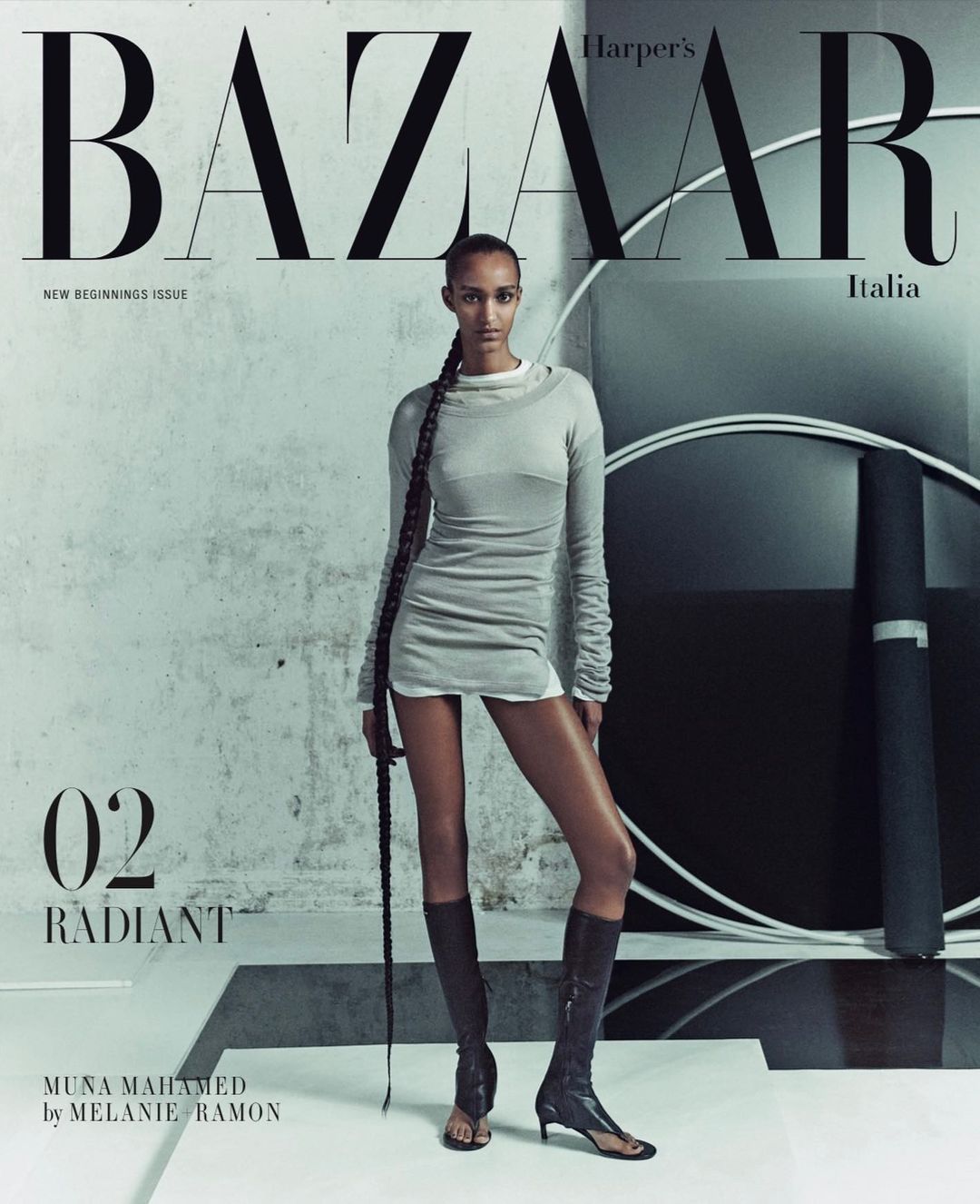 Fashion editorial magazine cover featuring a slender Black woman in a grey dress and knee-high boots posing in a photo studio.