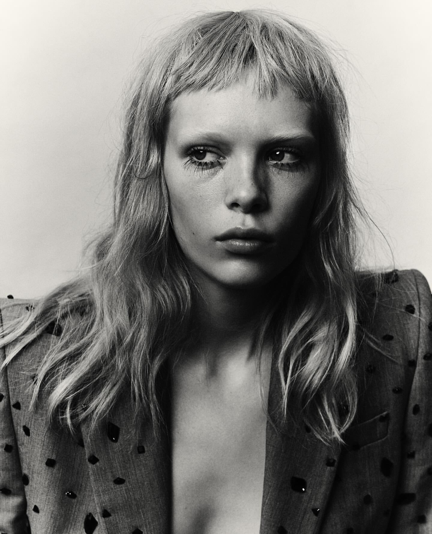 Portrait of a woman with bangs and textured jacket against a plain background by art directors Melanie and Ramon