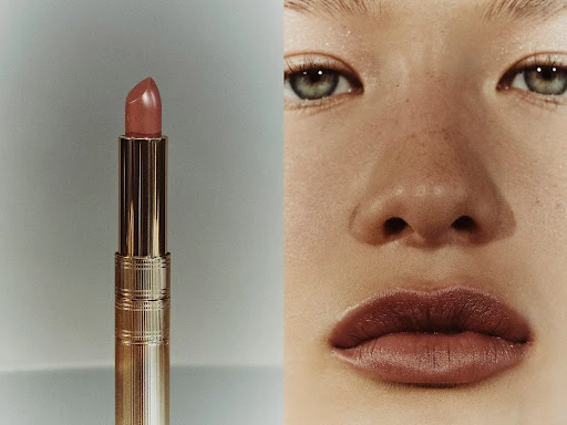 Close-up split image showing a metallic gold lipstick tube next to a person's face wearing matching lipstick and subtle eye makeup.