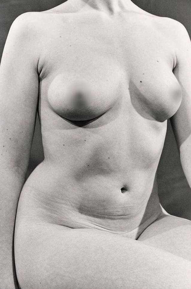 Monochrome close-up studio shot of an adult female torso, emphasizing skin texture and anatomical details under soft, diffused lighting.