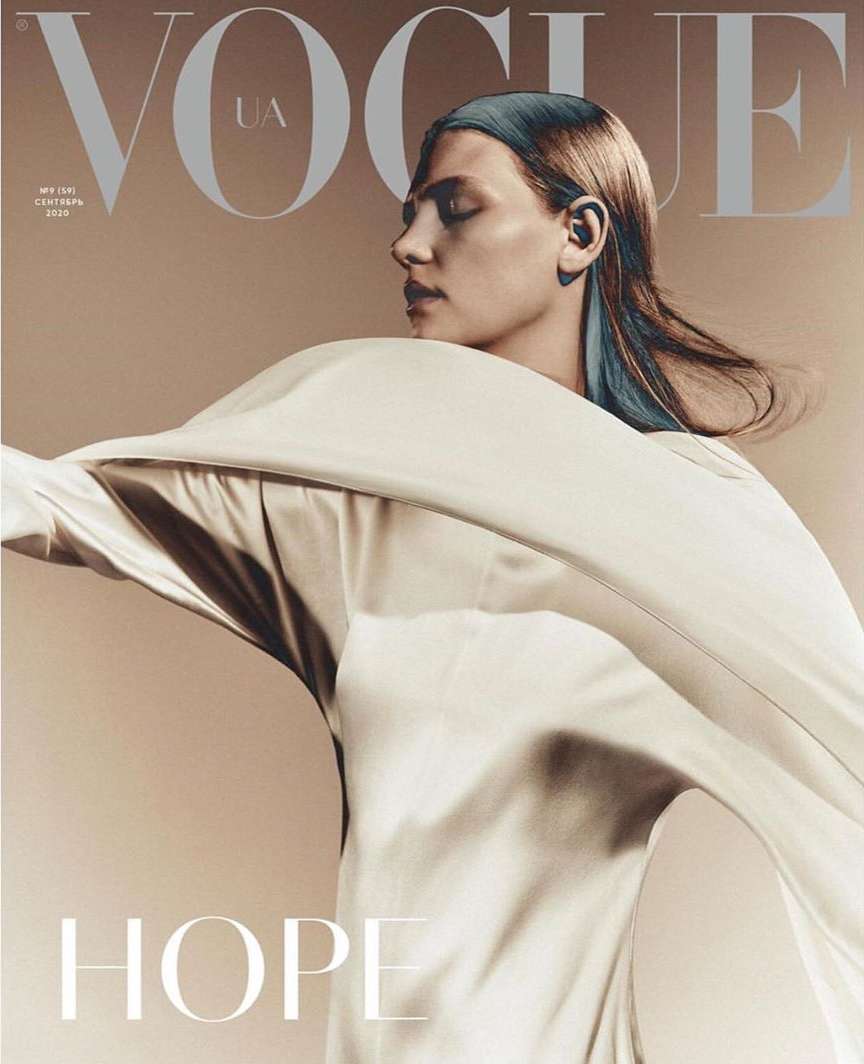 Vogue UA cover featuring a female model in a flowing white garment, set against a neutral backdrop, showcasing fashion and portrait photography.