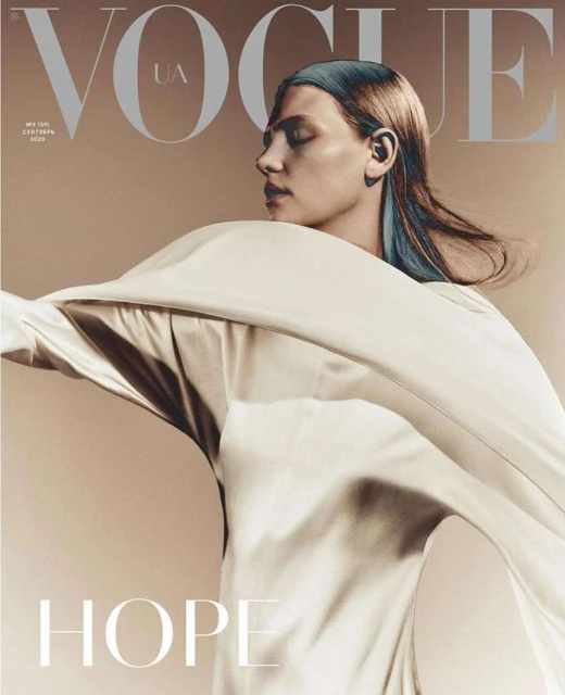 Vogue UA cover featuring a female model in a flowing white garment, set against a neutral backdrop, showcasing fashion and portrait photography.
