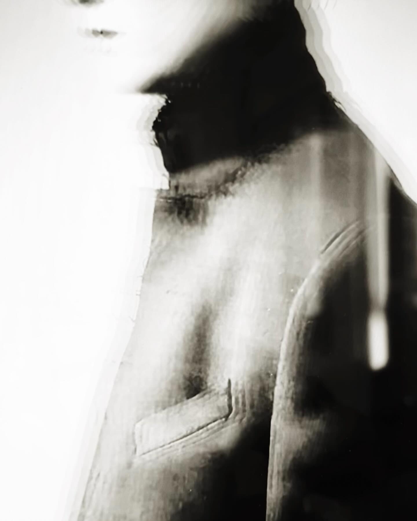 Monochrome portrait of a person in a high neck garment with glitch art distortion