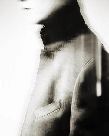 Monochrome portrait of a person in a high neck garment with glitch art distortion