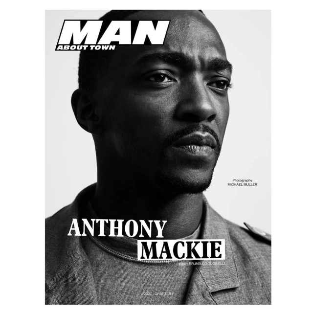 Black and white portrait of Anthony Mackie on a magazine cover, wearing a gray jacket and looking slightly off-center to the right.