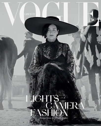 Vogue Greece cover featuring Sharon Stone in a wide-brimmed hat and black lace dress, posing in a desert-like setting with other models.