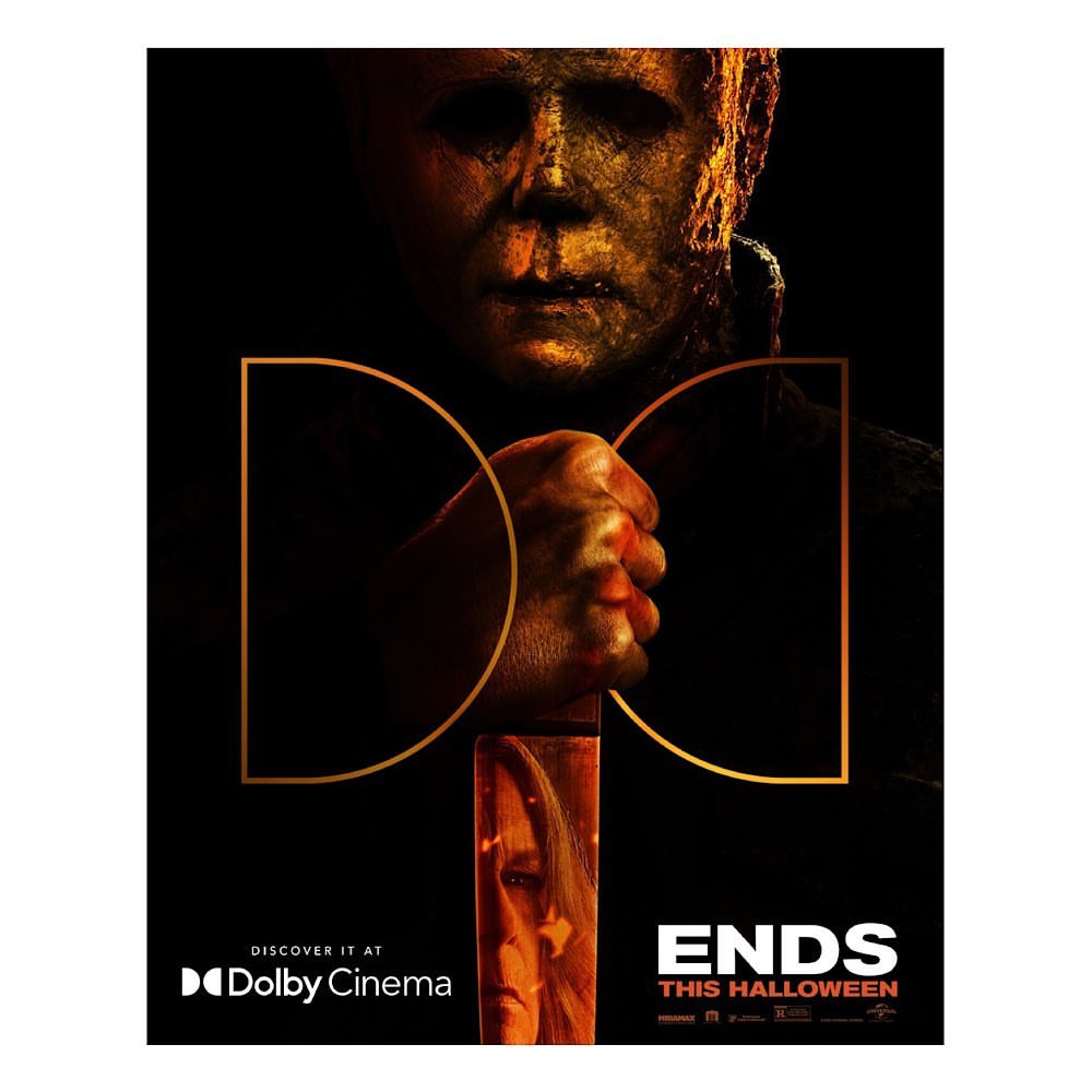 Movie poster for 'Halloween Ends' features Michael Myers mask, hand, and a partial view of Jamie Lee Curtis face, set against a dark background.