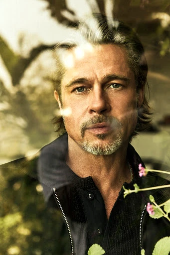 Portrait of Brad Pitt featuring reflections and foliage in the foreground captured by Michael Muller.