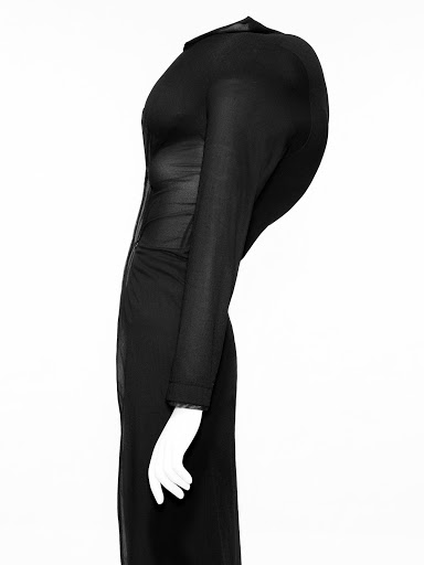 Elegant black dress showcased on a mannequin, featuring long sleeves and a form-fitting design against a stark white background.