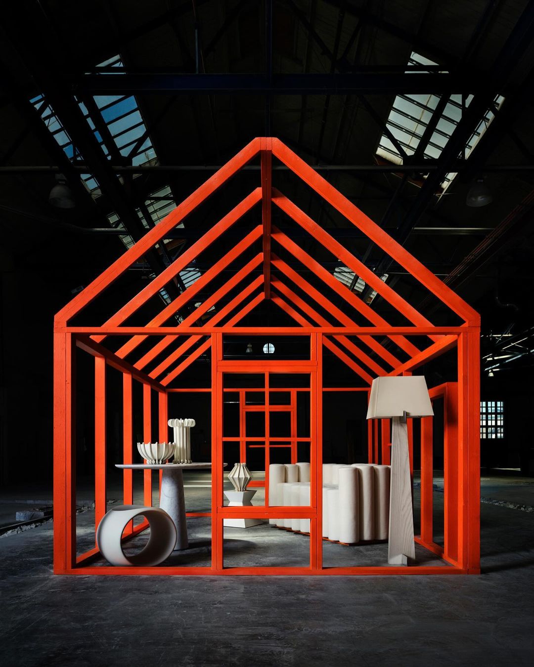 Minimalist design: orange house frame showcasing modern furniture in an industrial space, featuring geometric shapes and neutral color palettes.