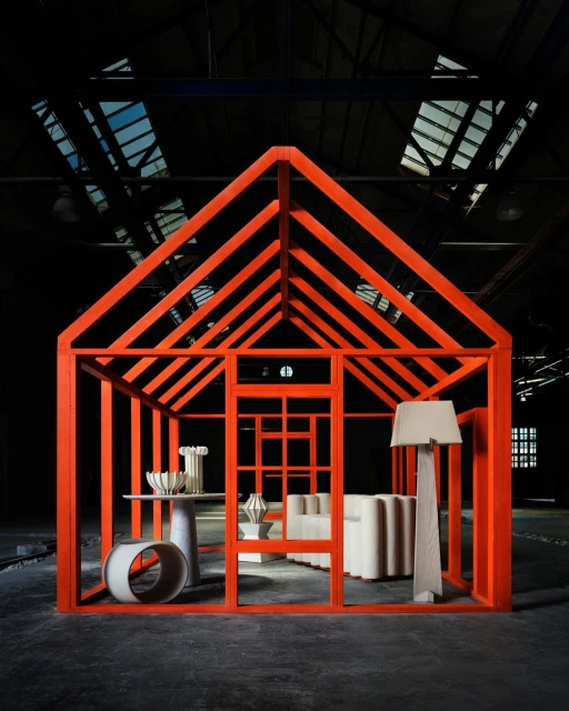 Minimalist design: orange house frame showcasing modern furniture in an industrial space, featuring geometric shapes and neutral color palettes.