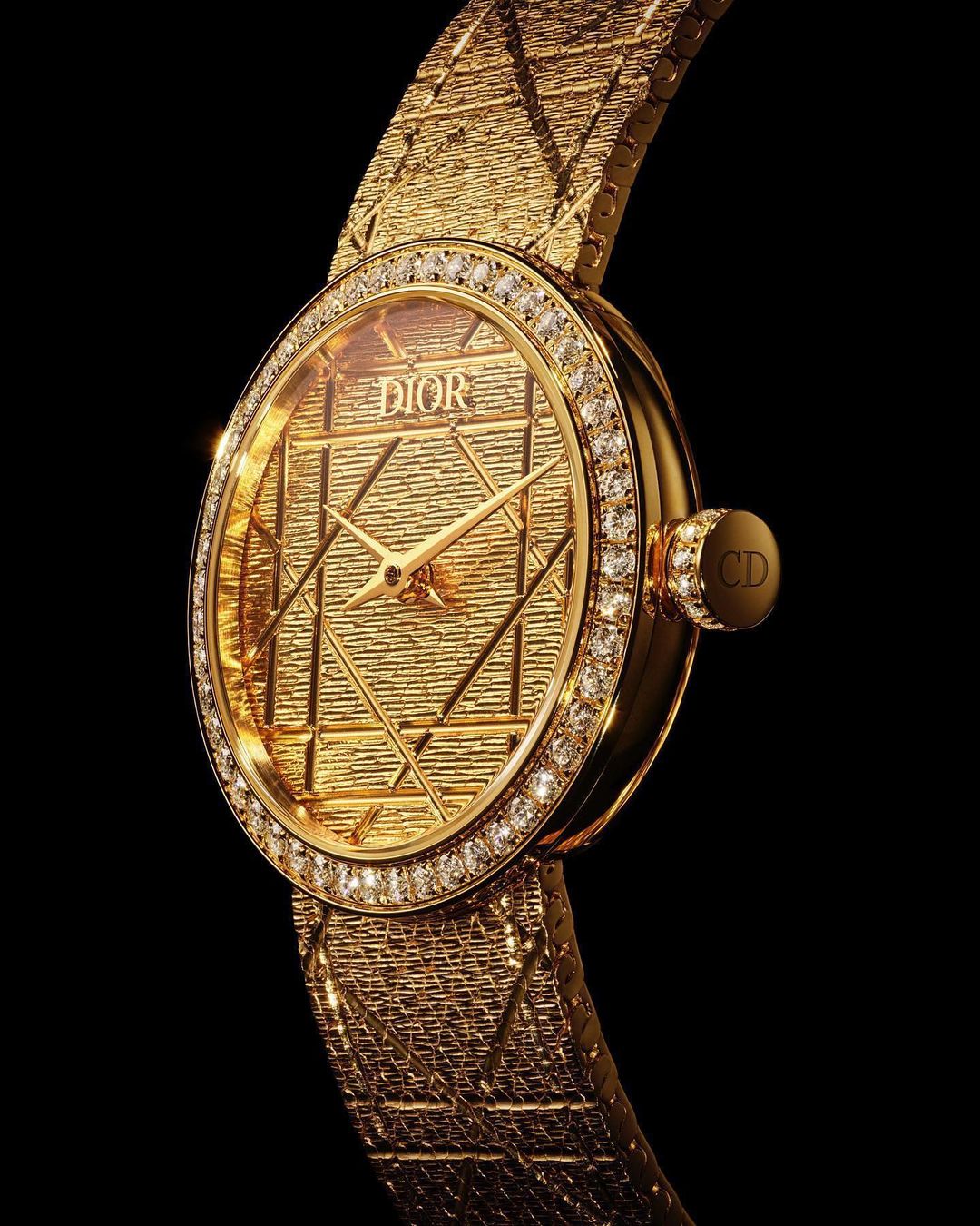 Gold Dior watch with diamond bezel, showcasing luxurious texture and design details on a black backdrop for high contrast and focus.