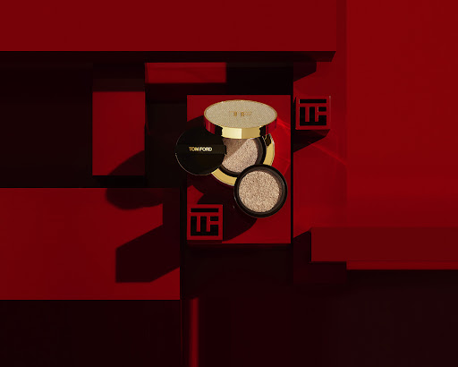 Still life shot of Tom Ford traceless touch foundation cushions on a red geometric background, showcasing beauty product. 