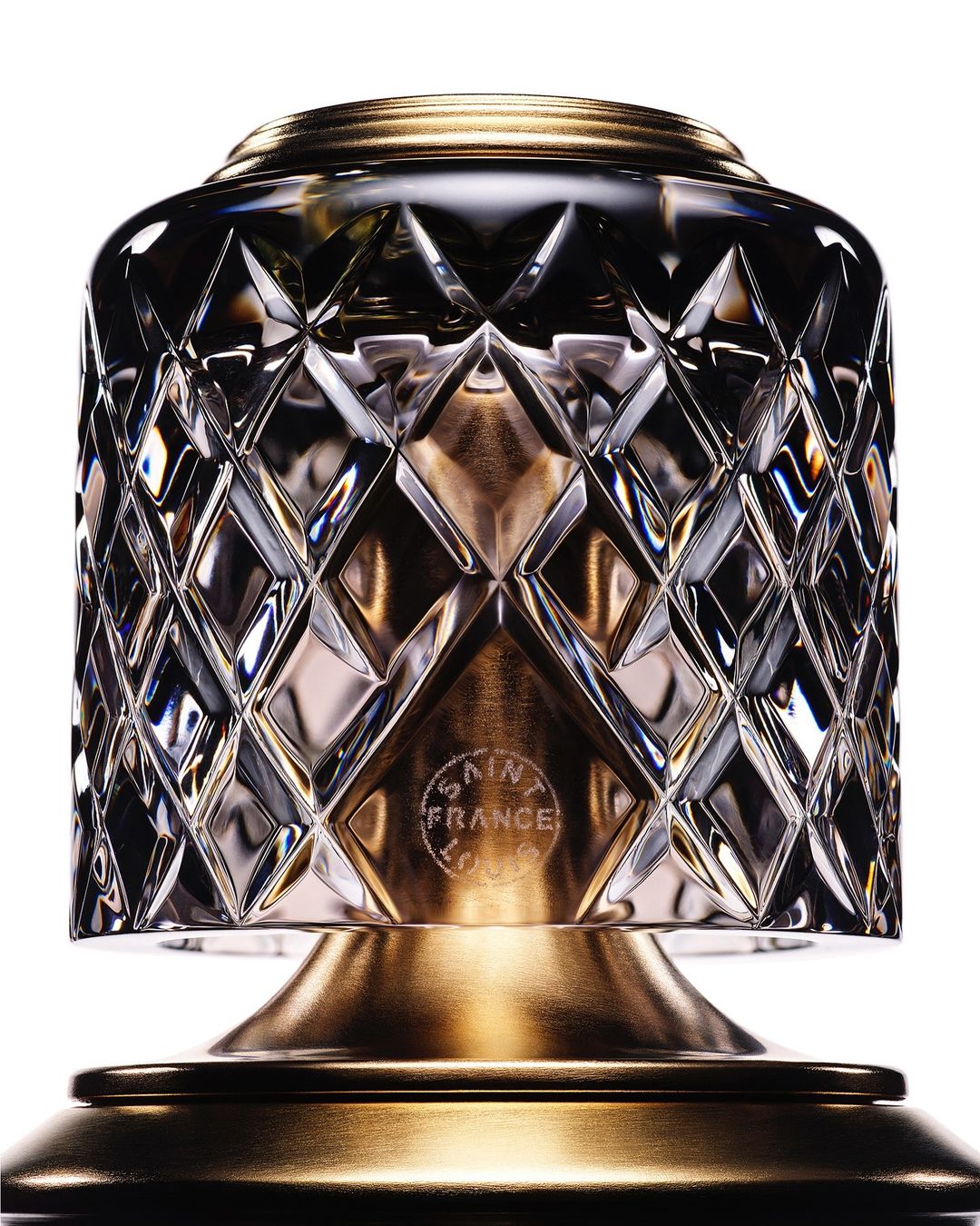 Close-up of a crystal table lamp featuring a diamond pattern and gold-colored accents on a white background, highlighting its design.